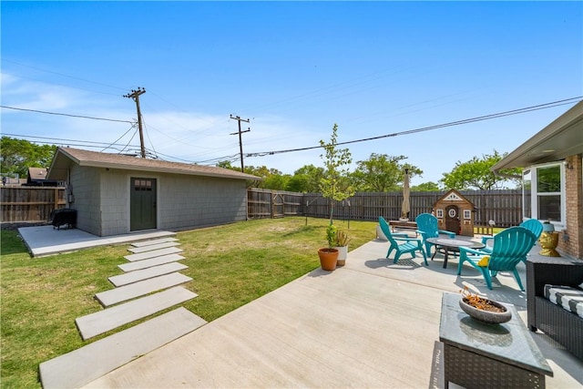 view of patio with a fenced backyard, a fire pit, and an outdoor structure