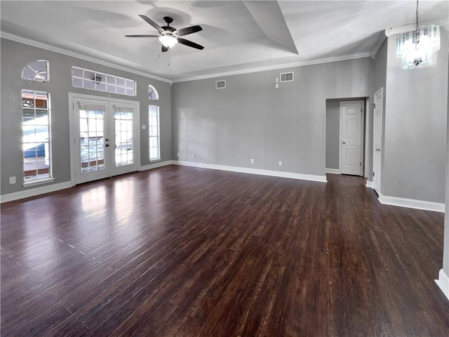 unfurnished room featuring dark hardwood / wood-style flooring, ceiling fan with notable chandelier, a raised ceiling, and french doors