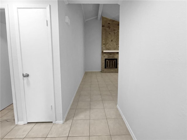 hallway with vaulted ceiling and light tile patterned floors