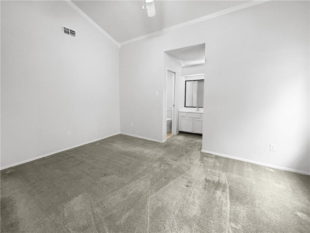 carpeted empty room with ceiling fan, vaulted ceiling, and crown molding