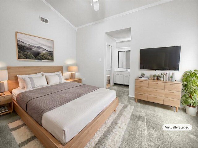 bedroom featuring ensuite bathroom, lofted ceiling, carpet flooring, ornamental molding, and ceiling fan