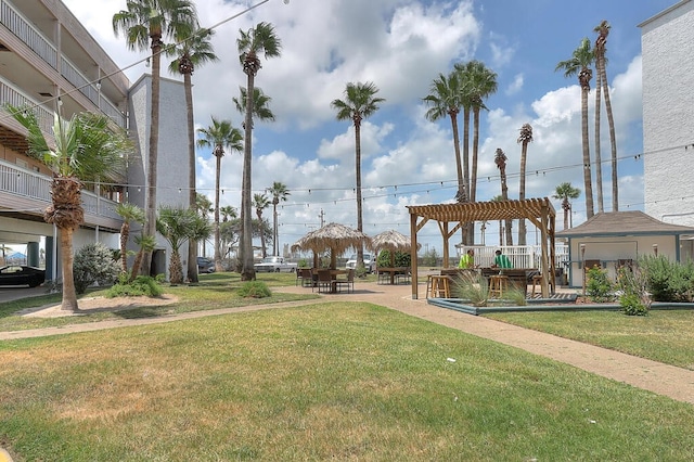 surrounding community featuring a yard and a pergola