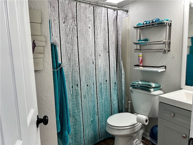 bathroom featuring curtained shower, vanity, and toilet