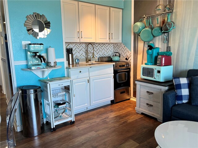 kitchen featuring tasteful backsplash, stainless steel electric range oven, dark hardwood / wood-style floors, and white cabinets