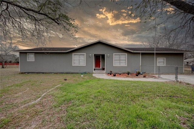 view of front of house with a gate, fence, and a yard