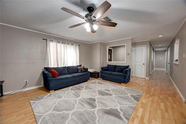 living area with light wood-type flooring, baseboards, visible vents, and ornamental molding