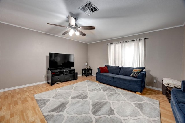 living room with light wood-type flooring, baseboards, visible vents, and ornamental molding