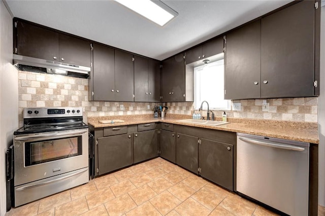 kitchen featuring appliances with stainless steel finishes, light countertops, a sink, and under cabinet range hood