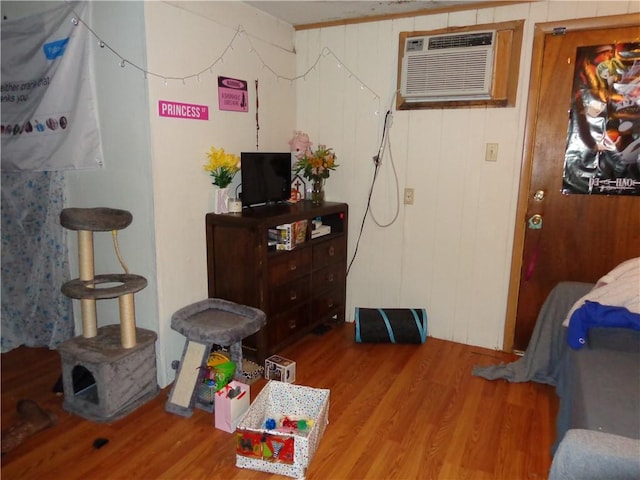 bedroom featuring a wall unit AC and wood finished floors