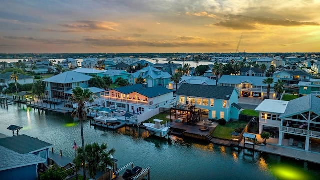 aerial view at dusk featuring a water view