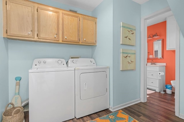 laundry room featuring separate washer and dryer, cabinets, a textured ceiling, sink, and dark hardwood / wood-style floors