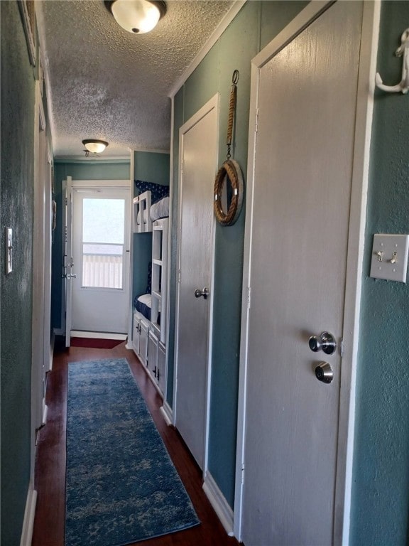 hallway featuring a textured ceiling, dark hardwood / wood-style flooring, and ornamental molding