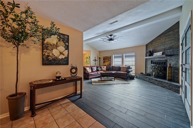 living room with hardwood / wood-style floors, a fireplace, lofted ceiling with beams, and a textured ceiling