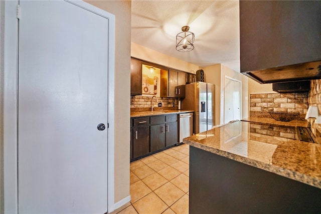 5213 Inverness Dr, Corpus Christi, TX 78413 - kitchen with tasteful backsplash, appliances with stainless steel finishes, light tile patterned floors, dark brown cabinets, and light stone counters