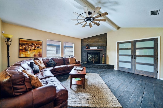 living room featuring vaulted ceiling with beams, a textured ceiling, dark hardwood / wood-style floors, ceiling fan, and a large fireplace