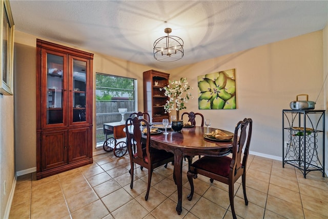 tiled dining space with a notable chandelier and a textured ceiling