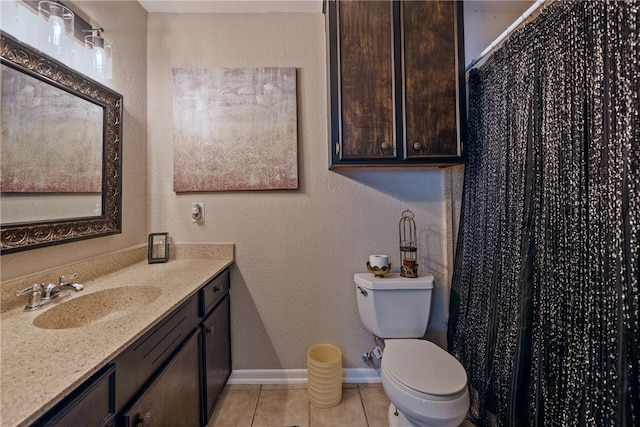 bathroom with tile patterned flooring, vanity, and toilet