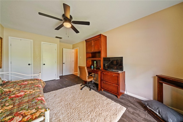 bedroom with dark hardwood / wood-style flooring and ceiling fan