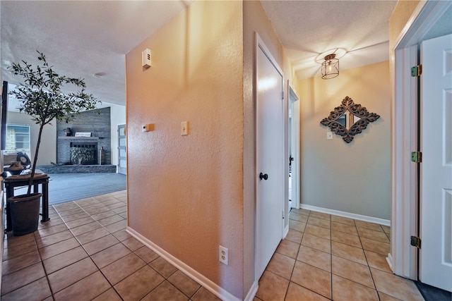 5213 Inverness Dr, Corpus Christi, TX 78413 - corridor featuring light tile patterned floors, a textured wall, a textured ceiling, and a chandelier
