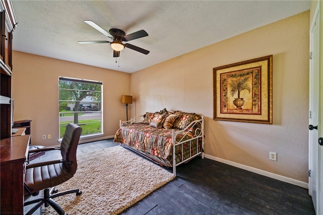 bedroom with a textured ceiling, dark wood-type flooring, and ceiling fan