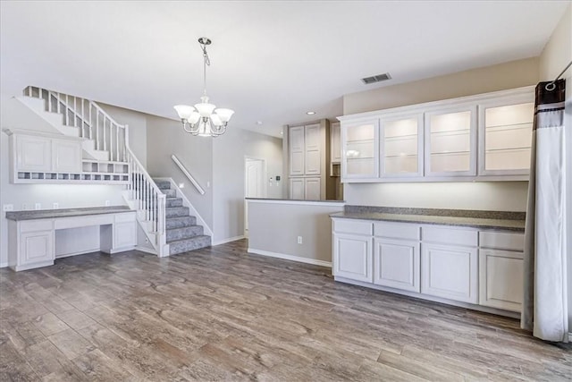 interior space with pendant lighting, light hardwood / wood-style flooring, and white cabinetry