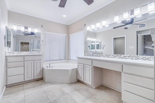 bathroom with a washtub, vanity, tasteful backsplash, and tile patterned flooring