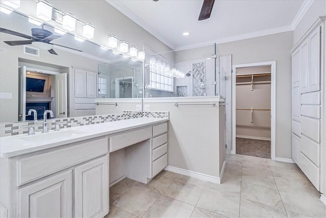 bathroom featuring ceiling fan, a shower, decorative backsplash, vanity, and ornamental molding