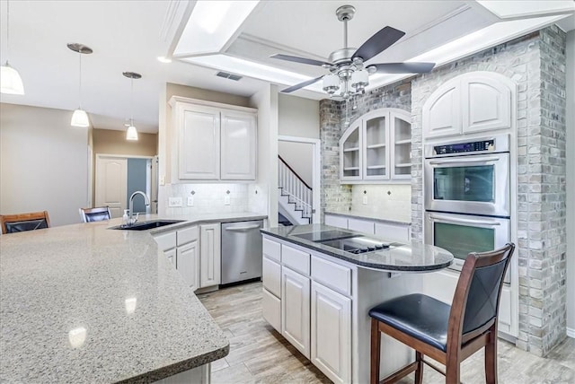 kitchen featuring sink, decorative backsplash, a breakfast bar, a kitchen island, and appliances with stainless steel finishes