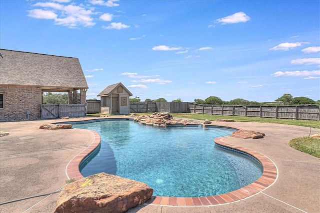 view of swimming pool with a patio and a shed