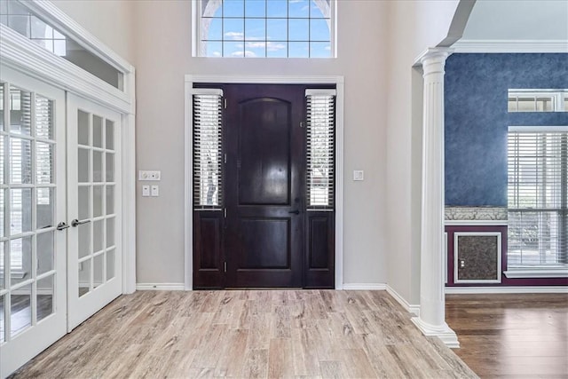 entryway with hardwood / wood-style floors, ornate columns, and french doors