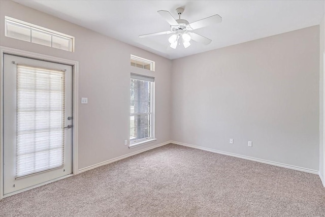 spare room featuring a wealth of natural light, ceiling fan, and light colored carpet