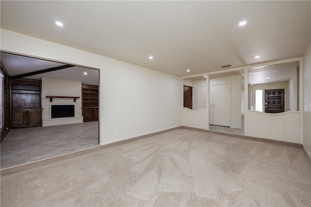 unfurnished living room with light carpet and a fireplace