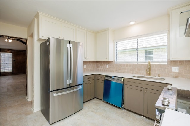 kitchen featuring appliances with stainless steel finishes, sink, tasteful backsplash, and gray cabinetry