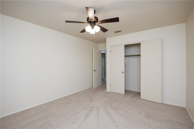 unfurnished bedroom with light colored carpet, ceiling fan, and a closet