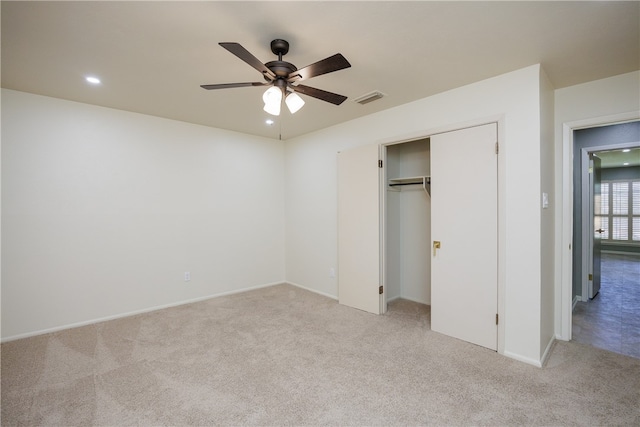 unfurnished bedroom featuring ceiling fan, a closet, and light colored carpet