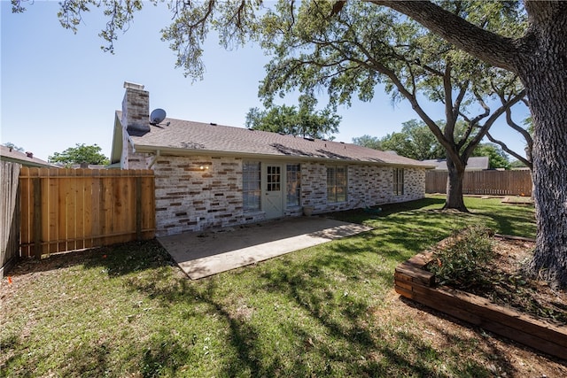 rear view of house featuring a lawn and a patio area