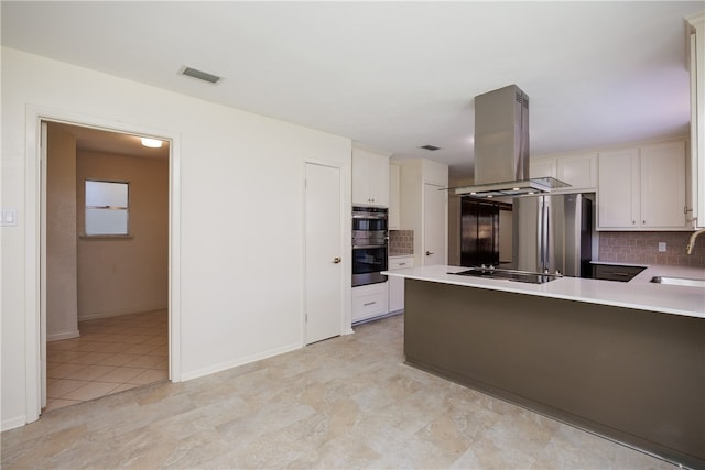 kitchen with tasteful backsplash, island exhaust hood, stainless steel appliances, and white cabinets