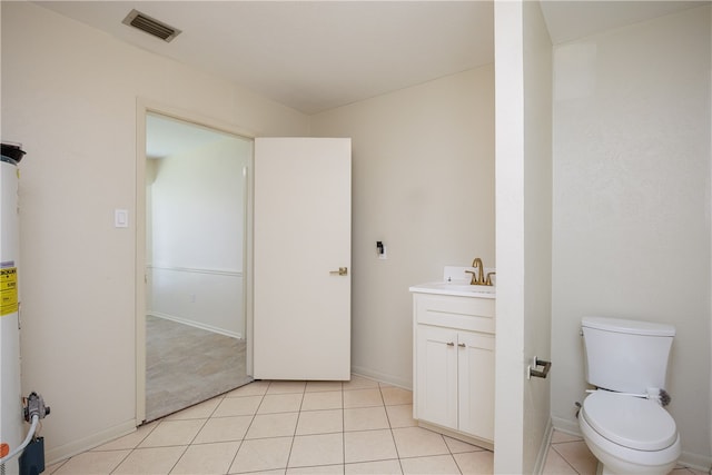 bathroom with tile patterned flooring, vanity, toilet, and water heater