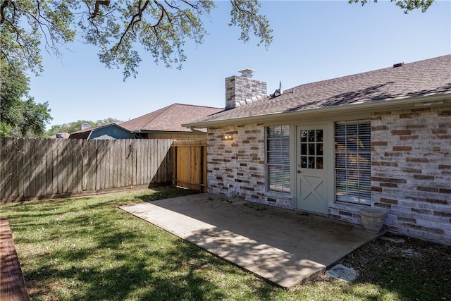 entrance to property featuring a patio and a yard