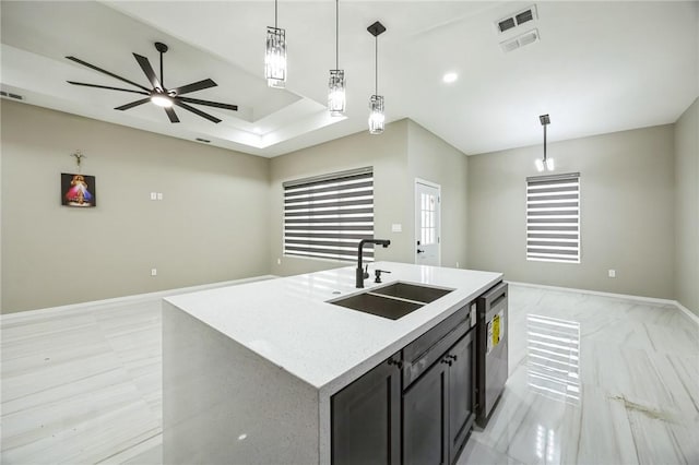 kitchen with pendant lighting, dishwasher, sink, and a center island with sink