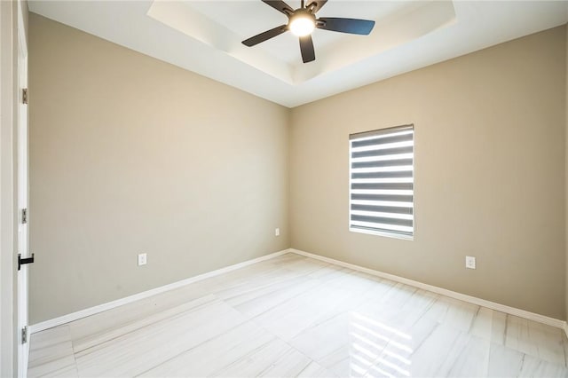 unfurnished room with a raised ceiling and ceiling fan