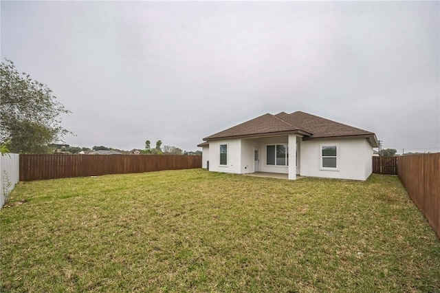 back of house with a patio and a lawn