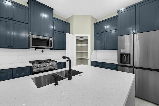 kitchen featuring light stone countertops, appliances with stainless steel finishes, and sink