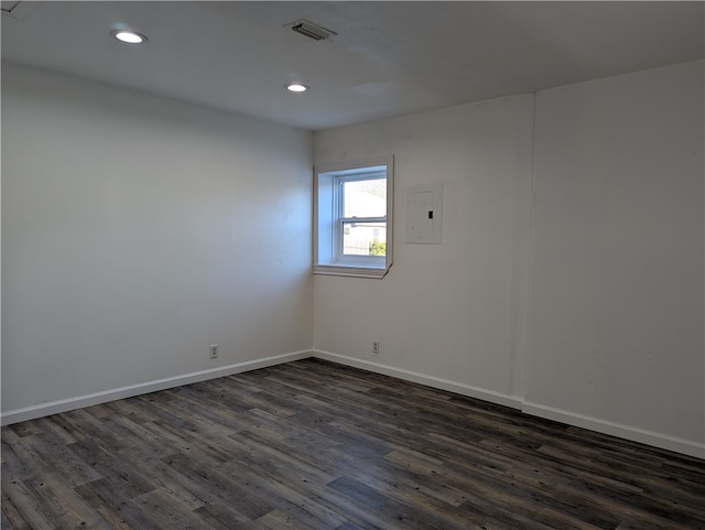 spare room featuring dark wood-type flooring and electric panel