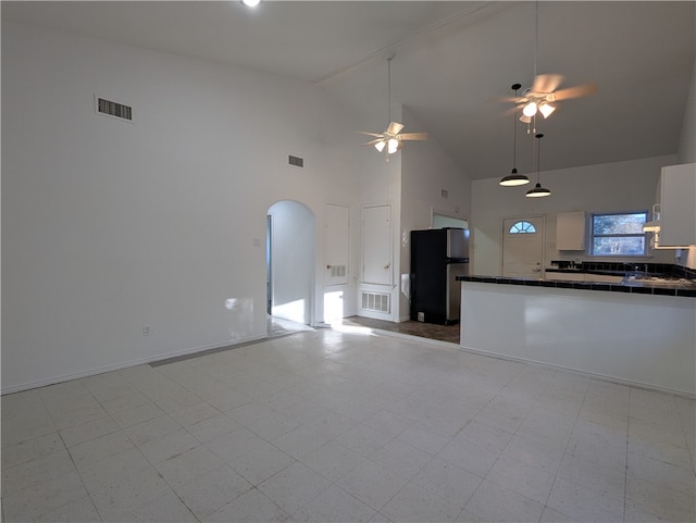 unfurnished living room featuring ceiling fan and high vaulted ceiling