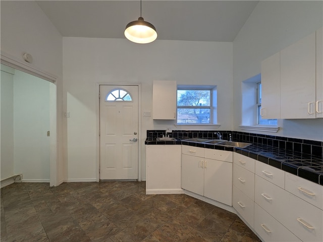 kitchen featuring pendant lighting, white cabinetry, and tile counters