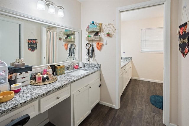 full bathroom featuring baseboards, wood finished floors, and vanity