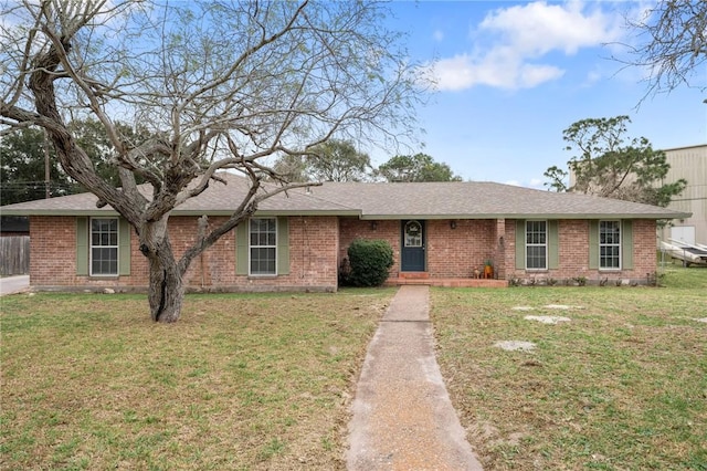 single story home with a front yard, brick siding, and roof with shingles