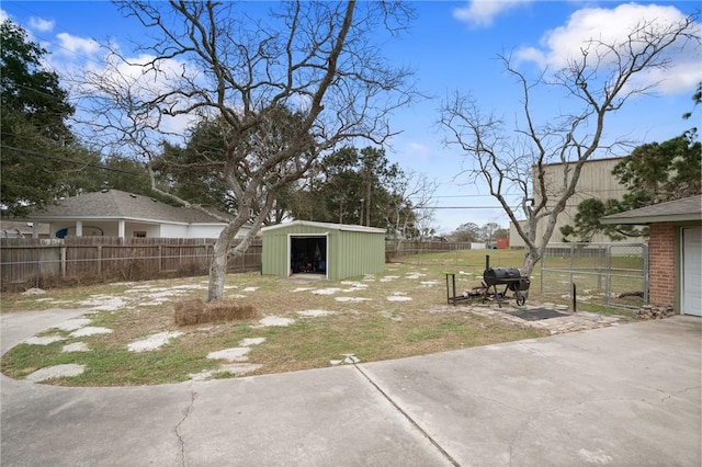 view of yard with fence, a patio, and an outbuilding