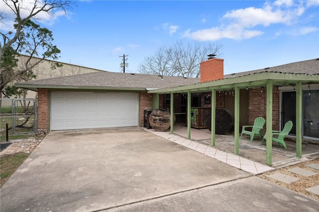 single story home with concrete driveway, brick siding, a chimney, and an attached garage